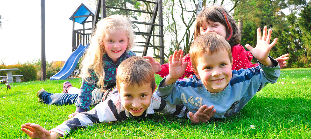 Kinder auf dem Kinderspielplatz, die uns anblicken